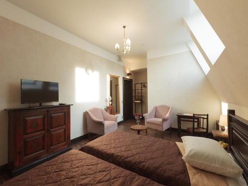 a bedroom with a bed and a flat screen tv at Basmanka Convent Hotel in Moscow