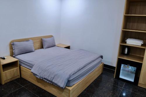 a small bedroom with a bed with blue pillows at Tuyet Suong Villa Hotel in Quang Ngai