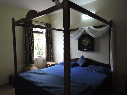 una camera con letto a baldacchino e lenzuola blu di 5 BHK Villa with private pool, Goa Garden Resort at Benaulim - Colva beach a Colva