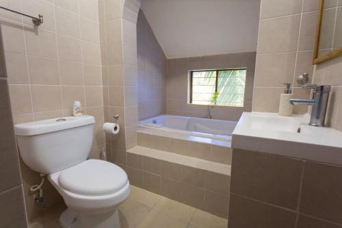 La salle de bains est pourvue de toilettes, d'un lavabo et d'une baignoire. dans l'établissement Tropical house in Downtown Cancún, à Cancún