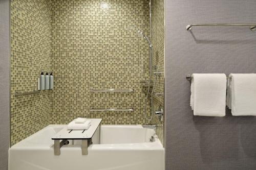 a bathroom with a white tub and a table in it at Residence Inn by Marriott Oakland Downtown in Oakland