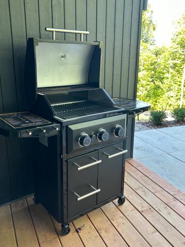 a grill sitting on a wooden deck with a grill at Luxury Mountain Retreat with Spa Near Mont Tremblant in La Conception