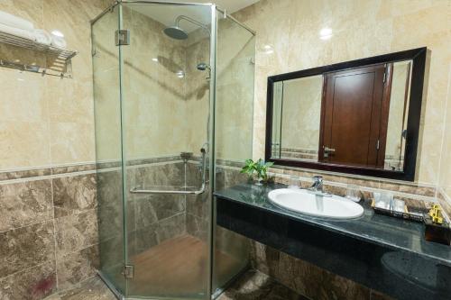 y baño con lavabo y ducha acristalada. en Tien Sa Danang Hotel, en Da Nang