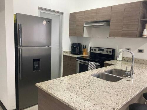 a kitchen with a stainless steel refrigerator and a sink at Hermoso Apartamento en Alajuela in Alajuela City