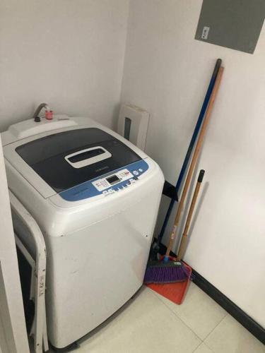 a washing machine in a room with some brushes at Hermoso Apartamento en Alajuela in Alajuela City