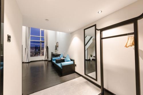 a living room with a blue couch and a mirror at Gongxili - Yuejian Hotel in Kunming