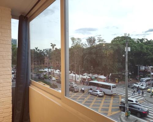 a window with a view of a parking lot with a bus at Center City Flats - Apartments in El Poblado near Park Lleras, Medellin! in Medellín