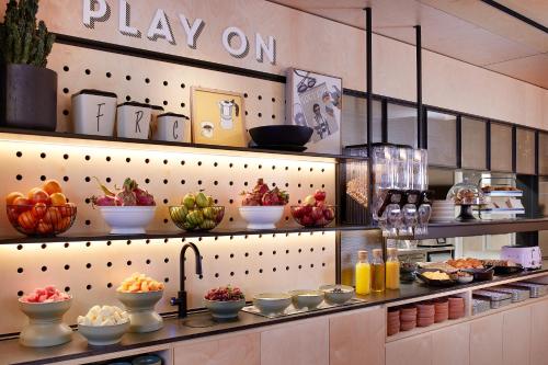 a kitchen with plates of food on shelves at Moxy Sydney Airport in Sydney