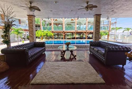 a living room with couches and a table and a pool at Amanzara Bohol Resort in Bolod