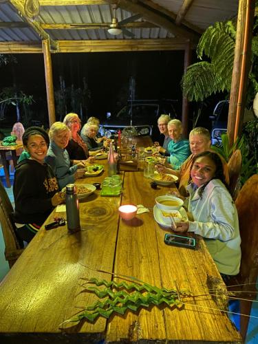 a group of people sitting around a wooden table at Daintree Siesta in Diwan