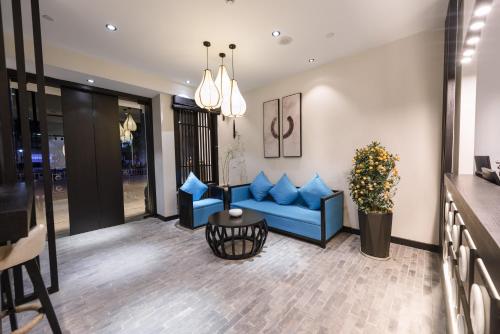 a living room with a blue couch and a table at Gongxili - Yuejian Hotel in Kunming