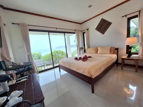 マーク島にあるSeabreeze @ Koh Makのベッドと大きな窓のある寝室