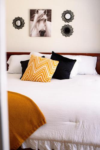 a white bed with pillows and pictures on the wall at Hadley's House - A Country 3 Bdrm with Screened-In Porch in New Braunfels