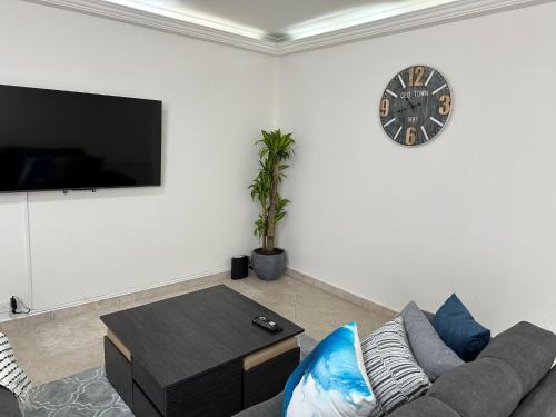 a living room with a couch and a clock on the wall at Center City Flats - Apartments in El Poblado near Park Lleras, Medellin! in Medellín