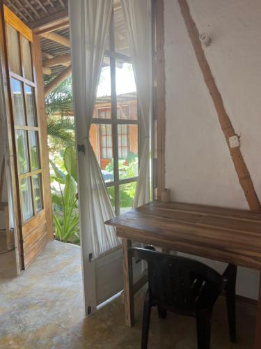 a room with a wooden table and a window at KUA Cabañas in Palomino
