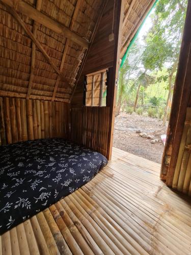 a room with a bed in the inside of a cabin at MoRue's Den in Mabini