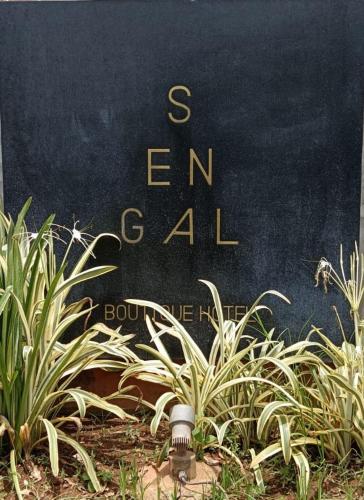 a sign that says end all behind some plants at Sengal Boutique Hotel in Auroville