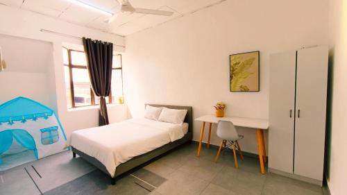 1 dormitorio con cama y escritorio. en 322 Kulai Tmn Bersatu 4BR 10pax Smart Tv near JPO en Kulai