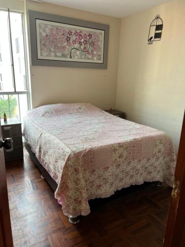 ein Schlafzimmer mit einem Bett und einem Bild an der Wand in der Unterkunft Depa en san Miguel in Lima