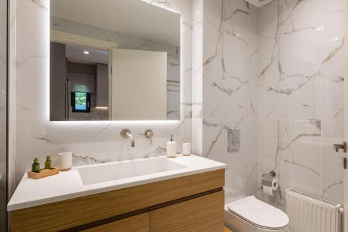 ein Badezimmer mit einem Waschbecken, einem WC und einem Spiegel in der Unterkunft Amazing Stay in Athen