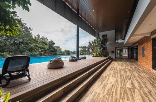a wooden deck with a chair next to a swimming pool at Family-Friendly 3-Bedroom Condo at IOI Resort City in Kampong Abu Bakar