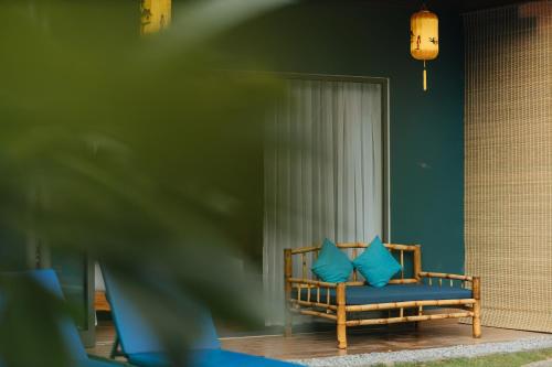 a bench with blue pillows in a room at Ngoc An Bang Villa in An Bang
