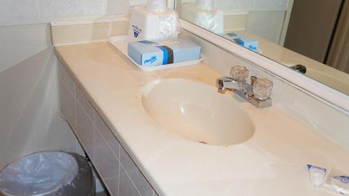 a bathroom counter with a sink and a mirror at Americas Best Value Inn & Suites Kansas City in Grandview