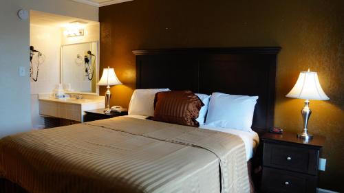 een hotelkamer met een groot bed en een wastafel bij Americas Best Value Inn & Suites Kansas City in Grandview