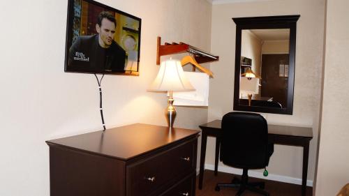 a room with a desk and a lamp and a mirror at Americas Best Value Inn & Suites Kansas City in Grandview