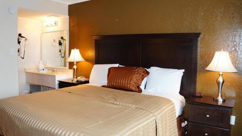 een slaapkamer met een groot bed en een wastafel bij Americas Best Value Inn & Suites Kansas City in Grandview