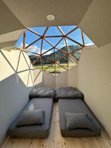 富士河口湖町にあるFuji Dome Glampingのベッド2台と大きな窓が備わる客室です。