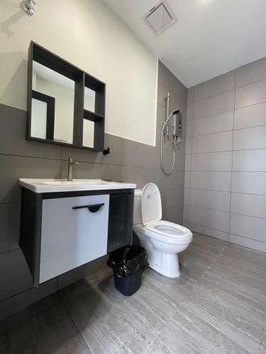 a bathroom with a toilet and a sink and a mirror at Nature Escape Cottage Cameron in Brinchang