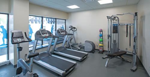 a gym with treadmills and machines in a room at L'Appartement Hôtel in Montréal