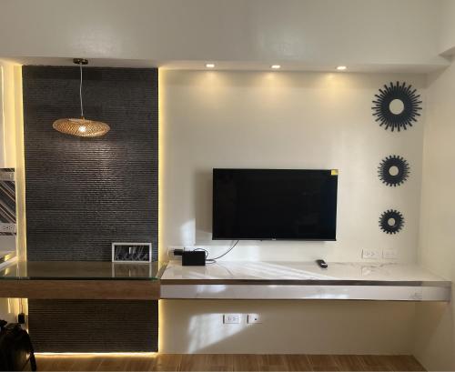 uma sala de estar com uma televisão de ecrã plano na parede em Aesthetic Functional Minimalist Space Sunvida Tower SV1716 em Cebu