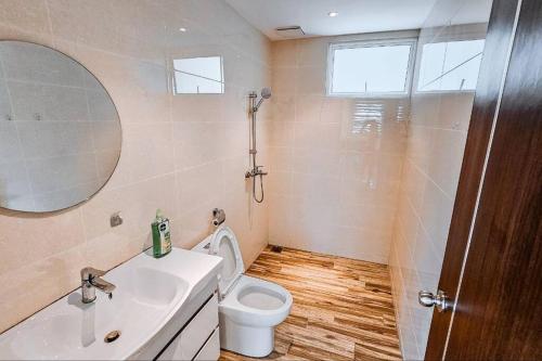 a bathroom with a toilet and a sink and a mirror at There's no place like home! By Mizu Homestay. in Miri