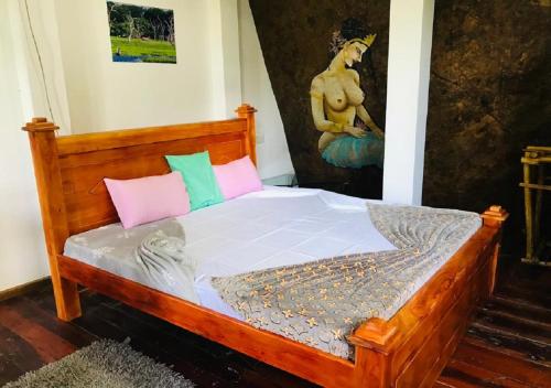 a bedroom with a wooden bed with pink and green pillows at Ella Camping Resort in Ella
