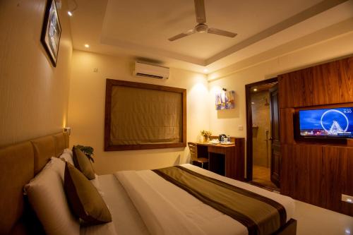 a hotel room with a bed and a tv at Metro Plaza Hotel by RAK Rooms, Mangaluru in Mangalore