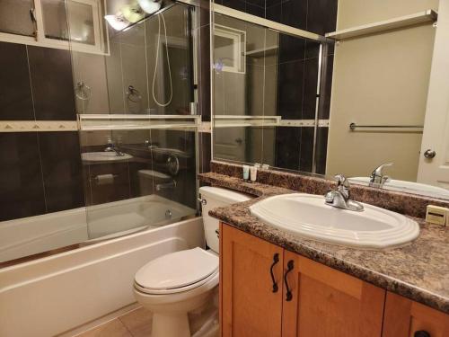een badkamer met een toilet, een wastafel en een douche bij Richmond BC Canada 1-Bedroom Suite in Richmond