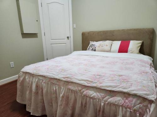 ein Schlafzimmer mit einem großen Bett mit einer rosa Decke in der Unterkunft Richmond BC Canada 1-Bedroom Suite in Richmond