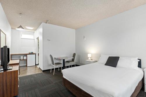 a hotel room with a large bed and a desk at Red Carpet Motel in Mount Gambier