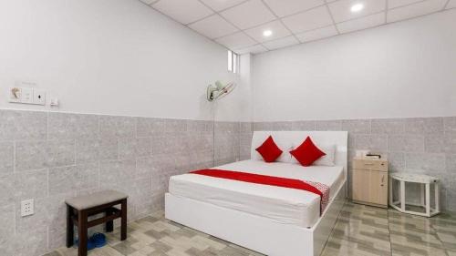 a bedroom with a white bed with red pillows at Vĩnh Phú Gia Hotel in Ho Chi Minh City