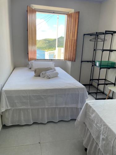 a bedroom with a white bed with a window at Casa Bela Vista in Piranhas