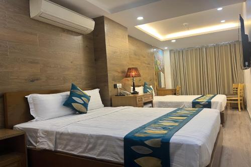 a hotel room with two beds and a television at Sao Mai Hotel in Ho Chi Minh City