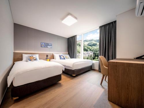 a hotel room with two beds and a window at Phoenix Resort Pyeongchang in Pyeongchang 