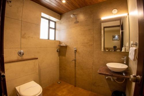 ein Bad mit einer Dusche, einem WC und einem Waschbecken in der Unterkunft Metro Plaza Hotel in Mangaluru