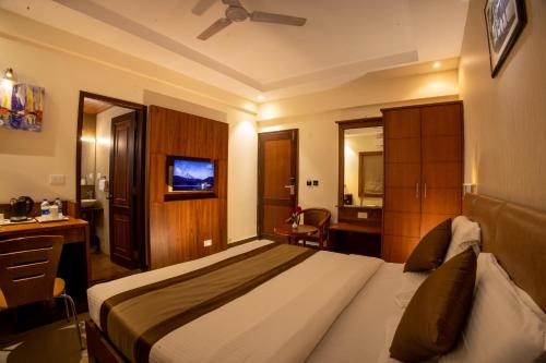 a hotel room with a bed and a desk at Metro Plaza Hotel by RAK Rooms, Mangaluru in Mangalore