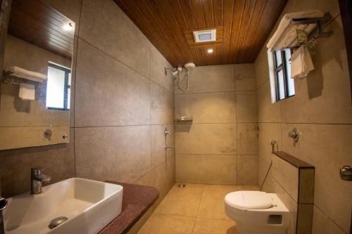 a bathroom with a toilet and a tub and a sink at Metro Plaza Hotel by RAK Rooms, Mangaluru in Mangalore