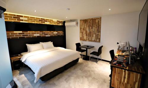 a bedroom with a white bed and a table and chairs at Incheon Illuwa Hotel in Incheon