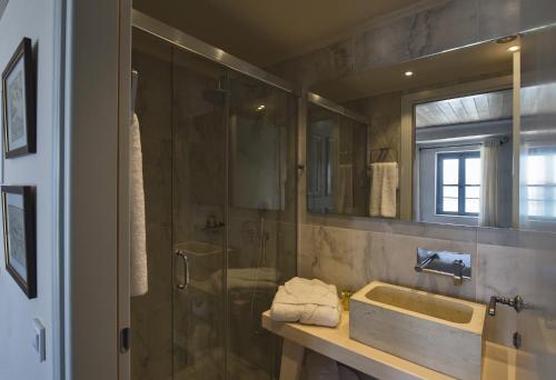 a bathroom with a shower and a sink and a mirror at Elia Zampeliou Hotel in Chania Town