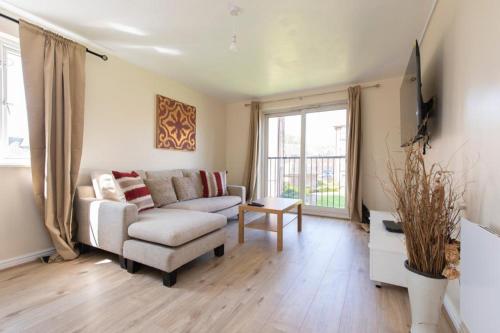ein Wohnzimmer mit einem Sofa und einem TV in der Unterkunft Modern 2 bed apartment 4 separate beds in Thamesmead in Thamesmead